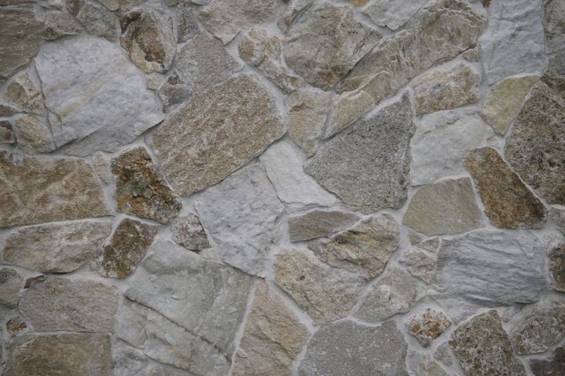 Close-up of a textured stone wall, featuring natural patterns and varied shades.
