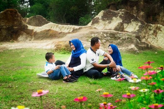 A joyful family picnic in a green park, enjoying nature and togetherness. - Fotografer Sidoarjo