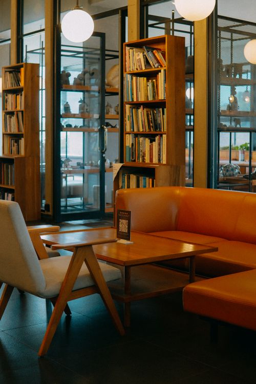Free A cozy reading nook in a modern cafe library with bookshelves, seating, and soft lighting. Stock Photo
