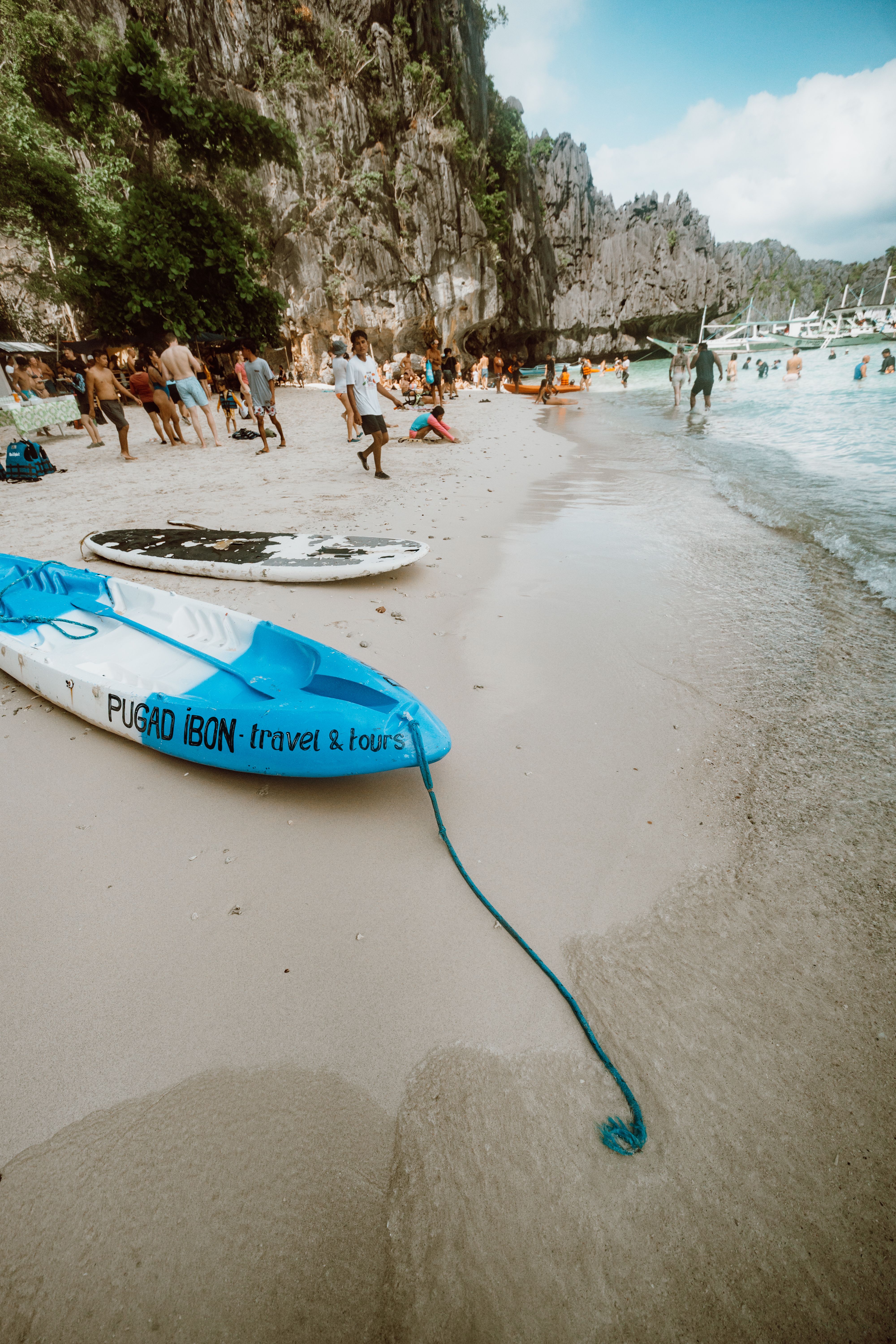 Sunny beach scene with people and kayaks, perfect for tropical getaways.