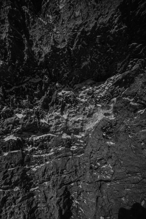 Free Detailed black and white close-up of a rugged rock surface highlighting textures and contrasts. Stock Photo