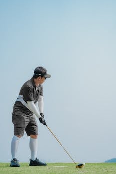 Golfer in action on a bright day in Costa Mesa, capturing a poised moment before swinging on the green.