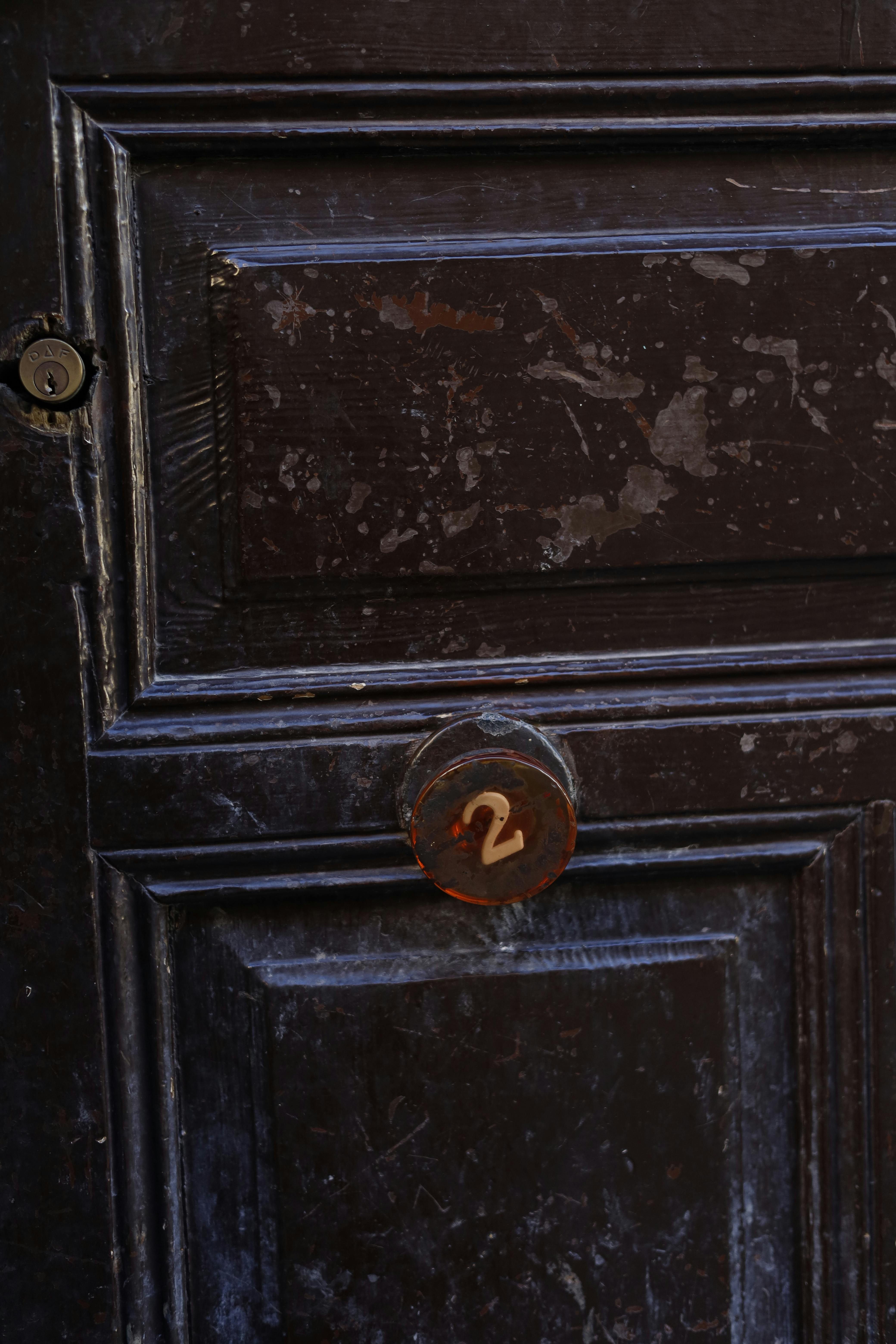 Gratis Nærbilde av en gammel tredør med et skilt med nummer to, som viser frem vintage-tekstur. Arkivbilde