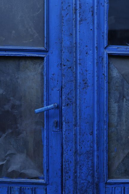 Aged blue wooden door with textured surface and vintage appeal, perfect for rustic and historical themes.