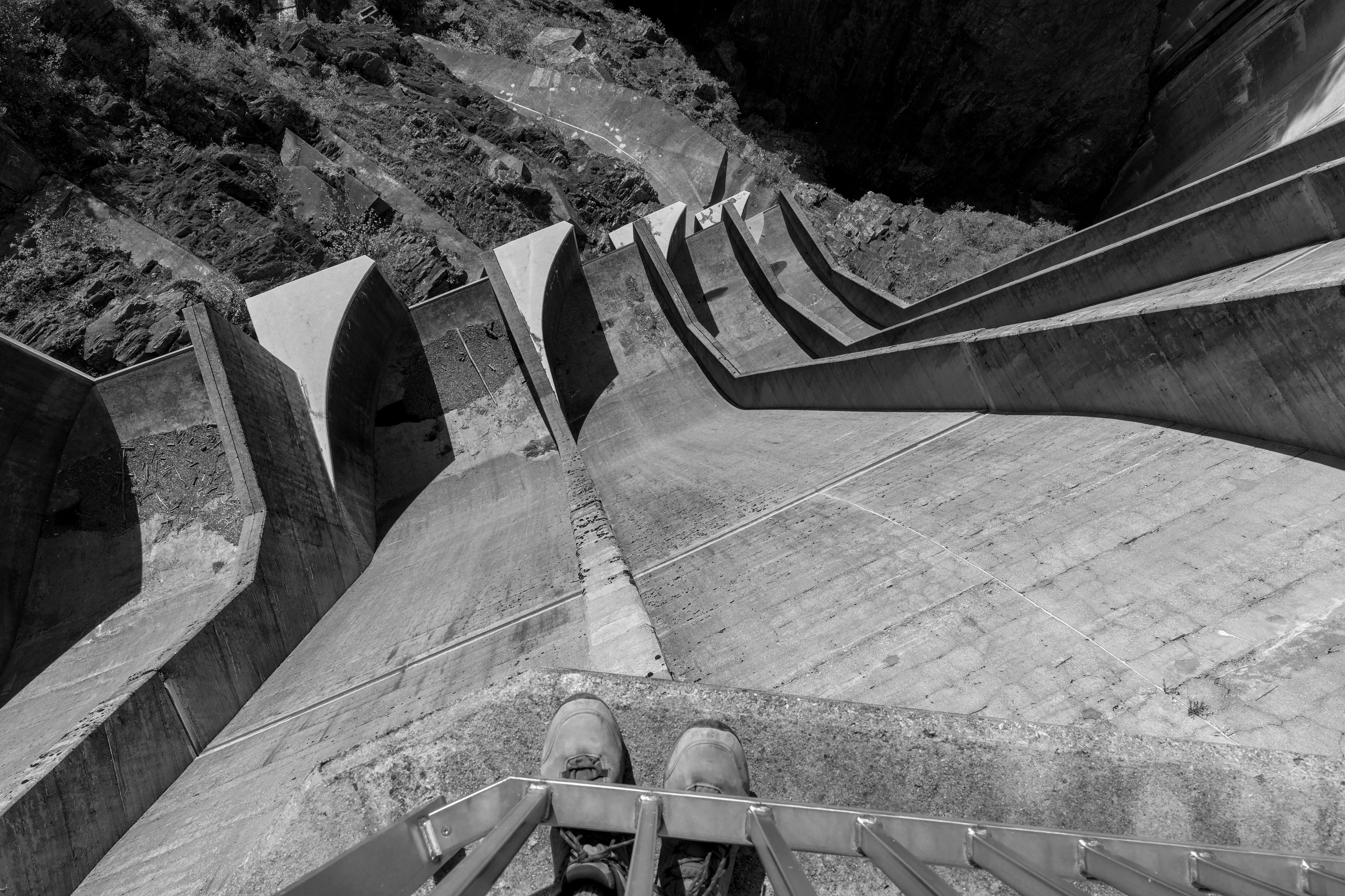 Black and white perspective from Verzasca Dam edge showing architectural depth.