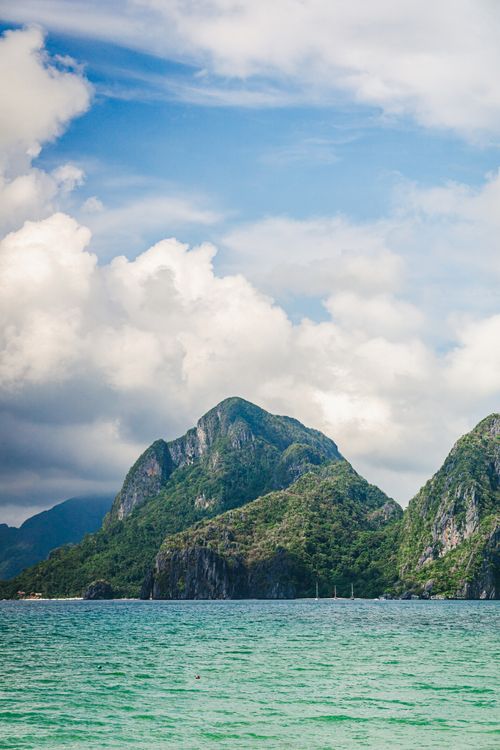 Free A picturesque view of limestone cliffs and clear ocean under a bright blue sky. Stock Photo