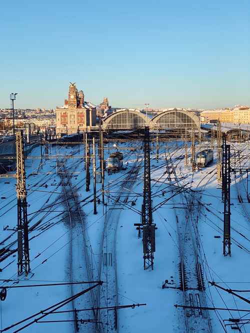 Free A snowy view of Prague's hlavní nádraží train station during winter, under a clear blue sky. Stock Photo