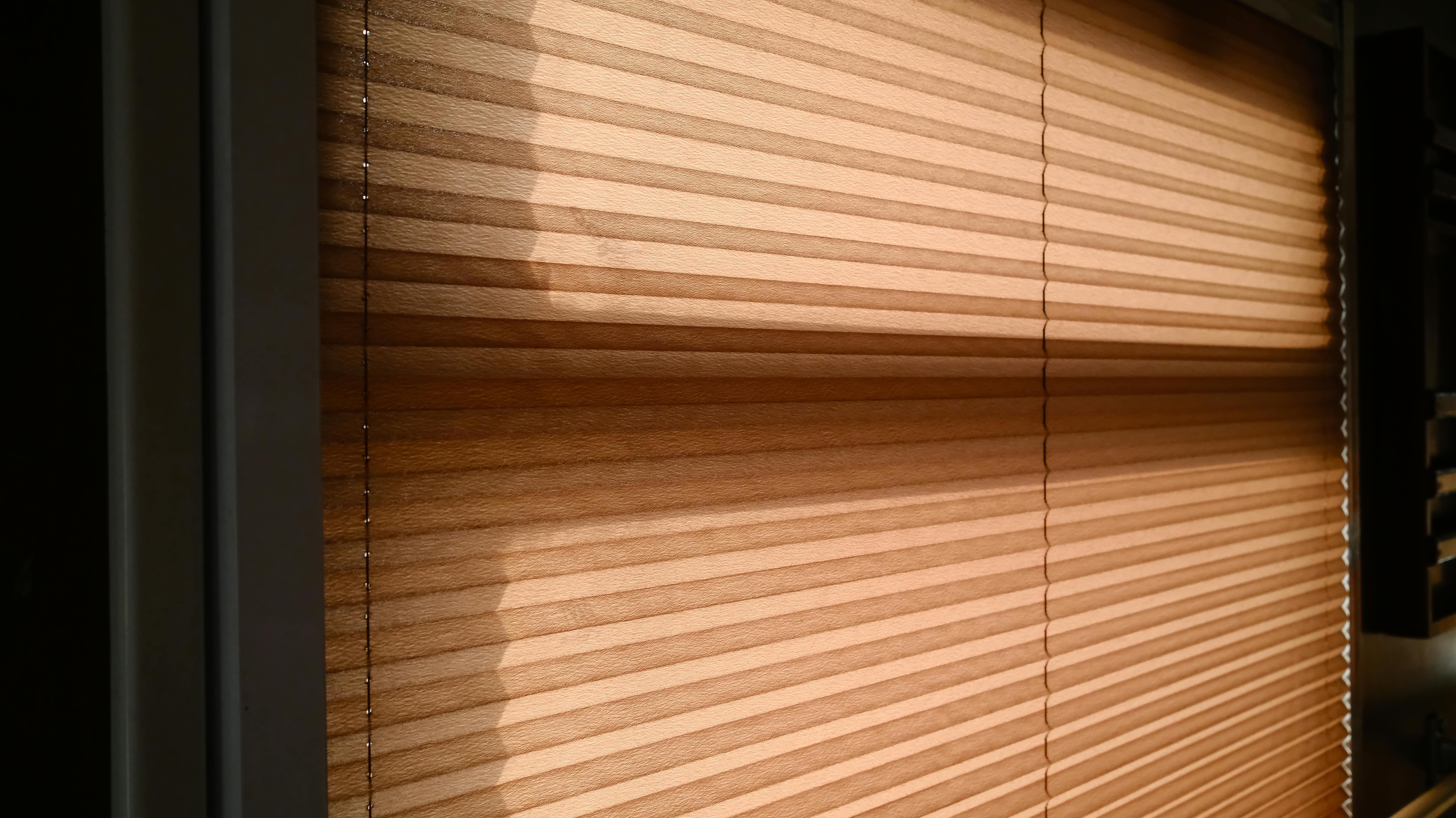 Detailansicht eines Wabenplissees am Fenster, seitliche Führung für bessere Abdunkelung und Wärmeschutz