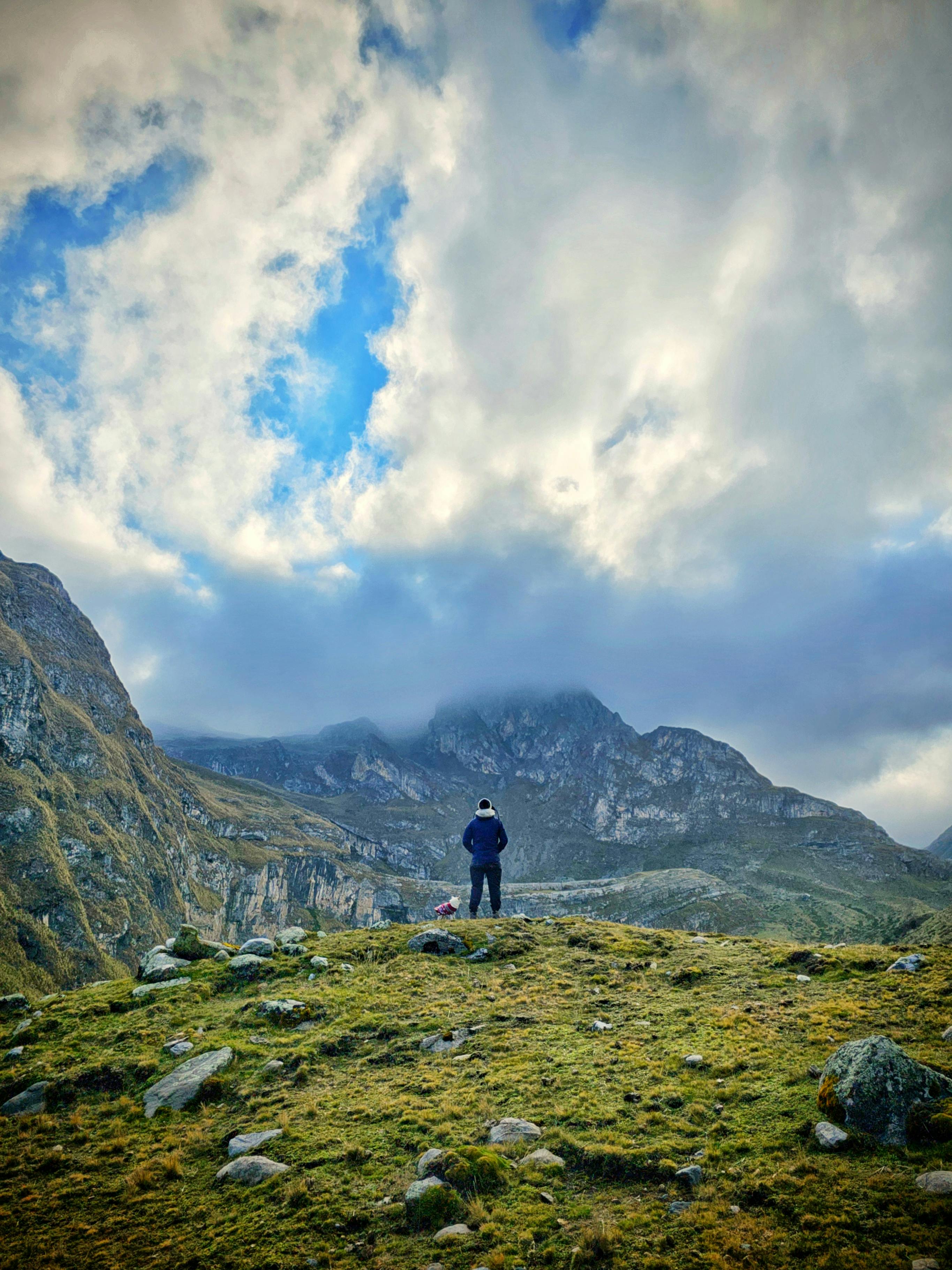 A lone hiker stands in the rugged Apurímac mountains under a dramatic sky.