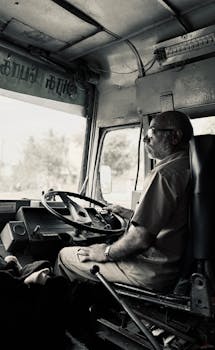 A nostalgic look at a bus driver on duty in Vellore, India, capturing vintage charm.