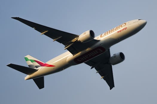 Emirates SkyCargo aircraft flying overhead during clear skies at day.