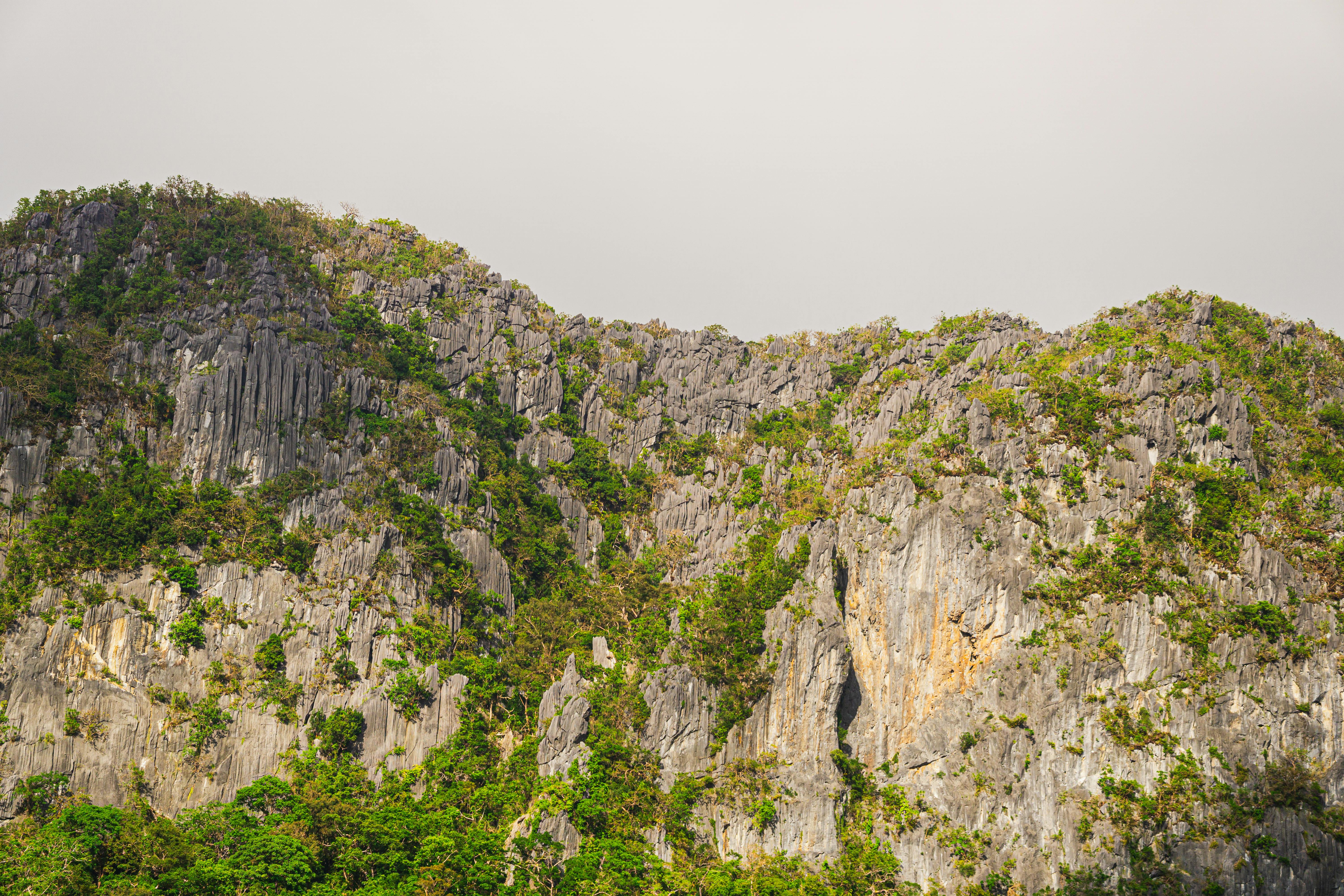 Montañas kársticas calcáreas rodeadas de colinas verdes en Laos con luz del día.