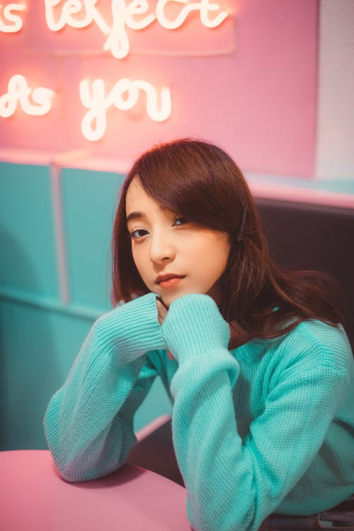 Free Girl in Sweater Sitting in Front of Table Stock Photo