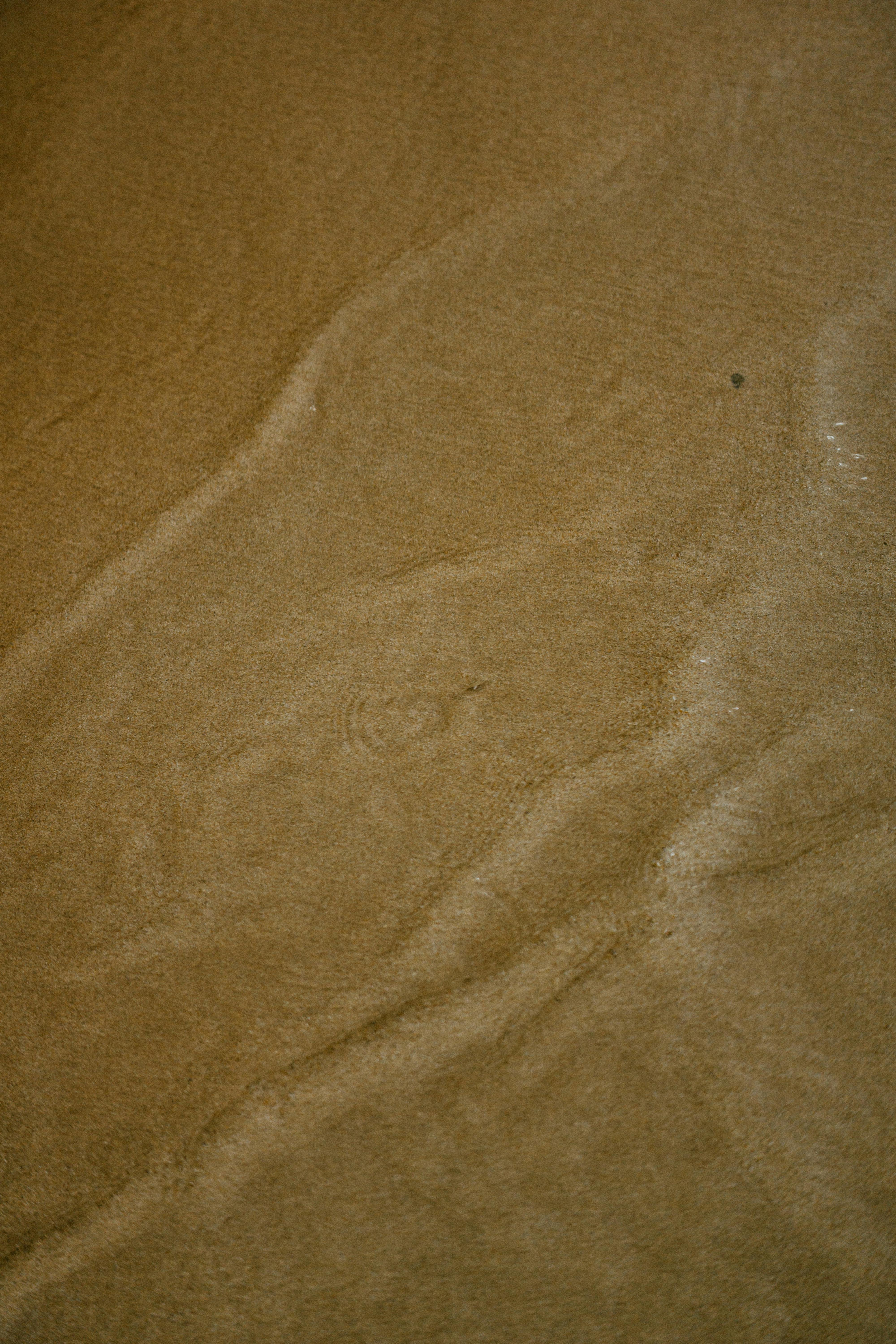 Free Close-up of sandy beach texture showing wave patterns, evoking a calm and natural feel. Stock Photo