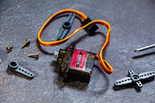 Close-up shot of a MG90S micro servo motor and its components, ideal for robotics and electronics projects.