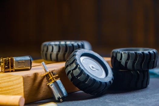 Detailed view of robotic wheels and motors on a workshop table, showcasing components for building robotics projects.