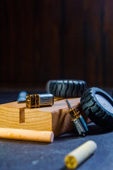 Close-up of robotics kit parts on wooden block, showcasing components like motors and wheels.