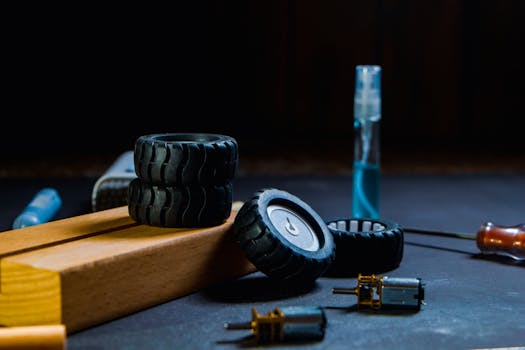 Close-up of robotics kit parts including wheels, motor and tools on a workbench.