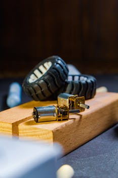 Detailed close-up of robot wheel components and motors on a wooden base, ideal for tech projects.