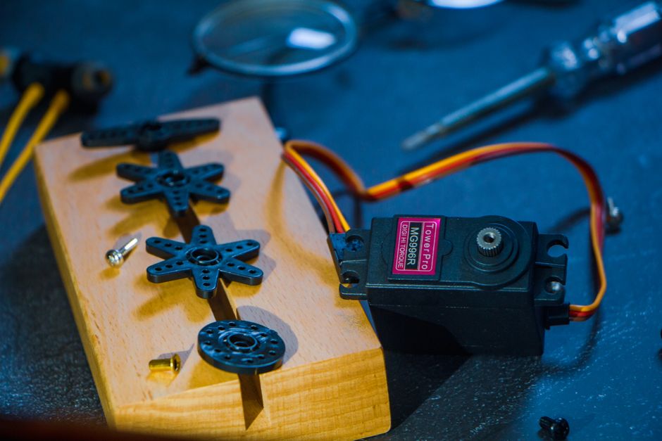A servo motor and gear set on a wooden block, perfect for robotics enthusiasts and engineers. - High Quality Performance Evaluation