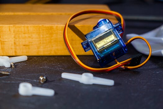 Close-up of a micro servo motor and components for robotics assembly.