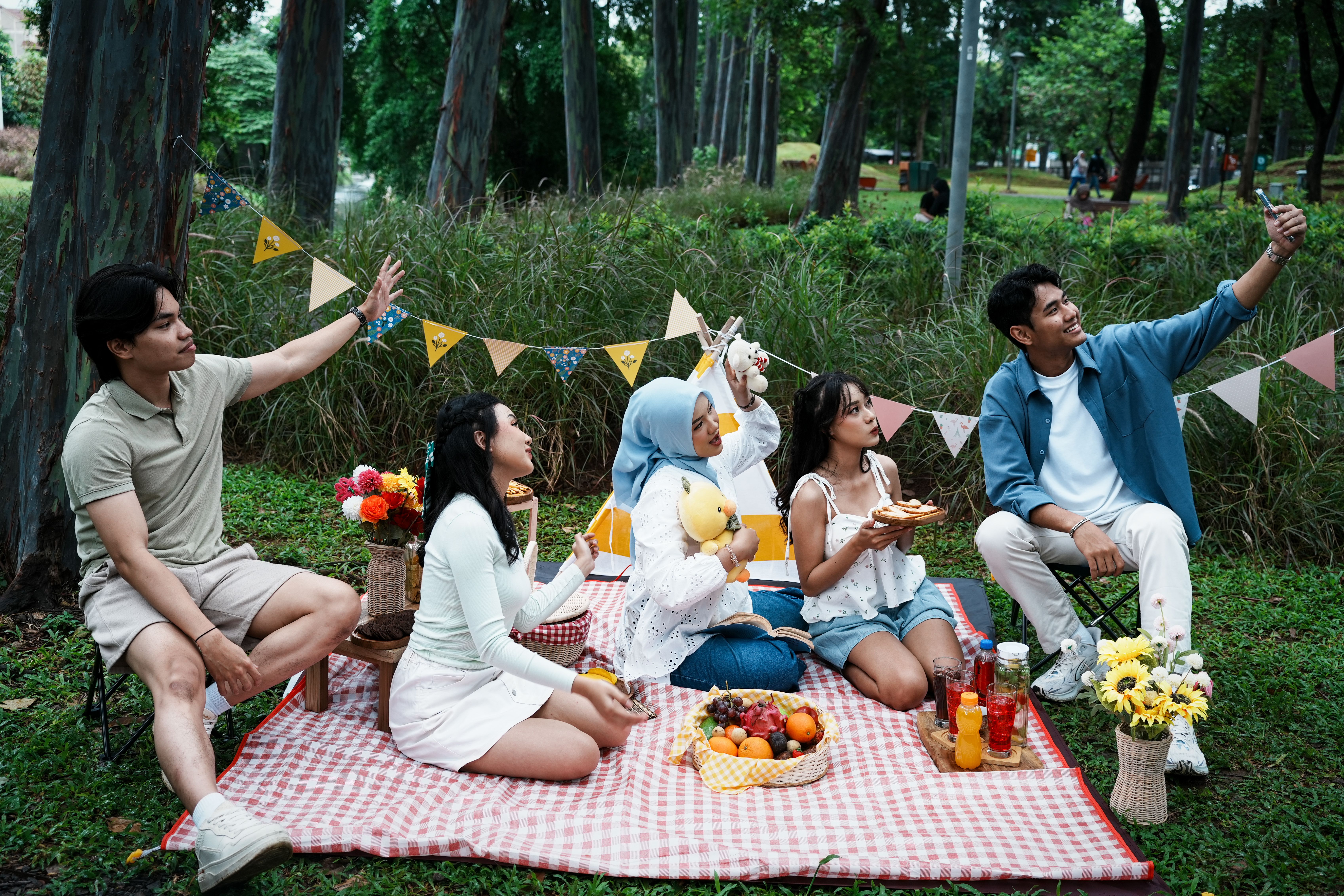 Diverse Group Enjoying Picnic in Lush Park Setting · Free Stock Photo