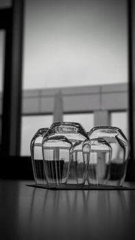 Artistic arrangement of glassware indoors with a modern architectural background.