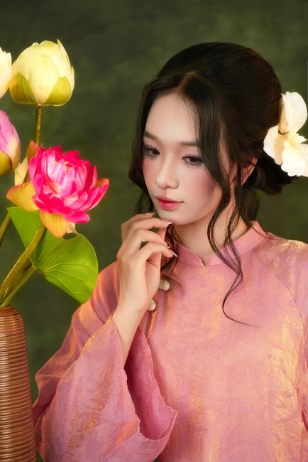 Portrait of a woman in traditional pink attire with lotus flowers, tranquil and serene.