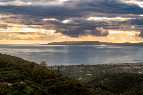 Free A dramatic sunset over the coastal landscape with a view of the sea and distant islands. Stock Photo