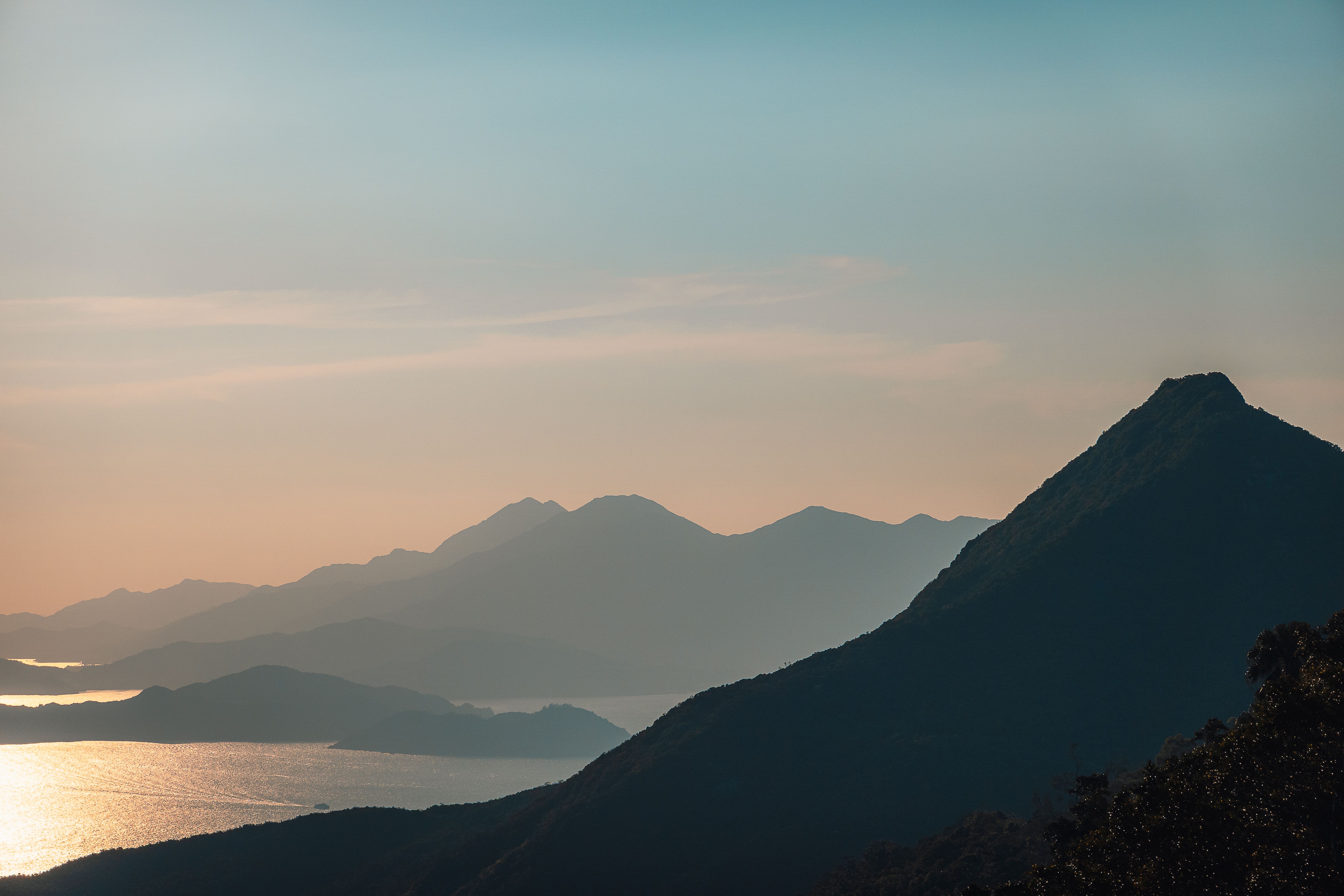 Serene mountain silhouette with sunset glow on Hong Kong Island, offering a tranquil natural view.