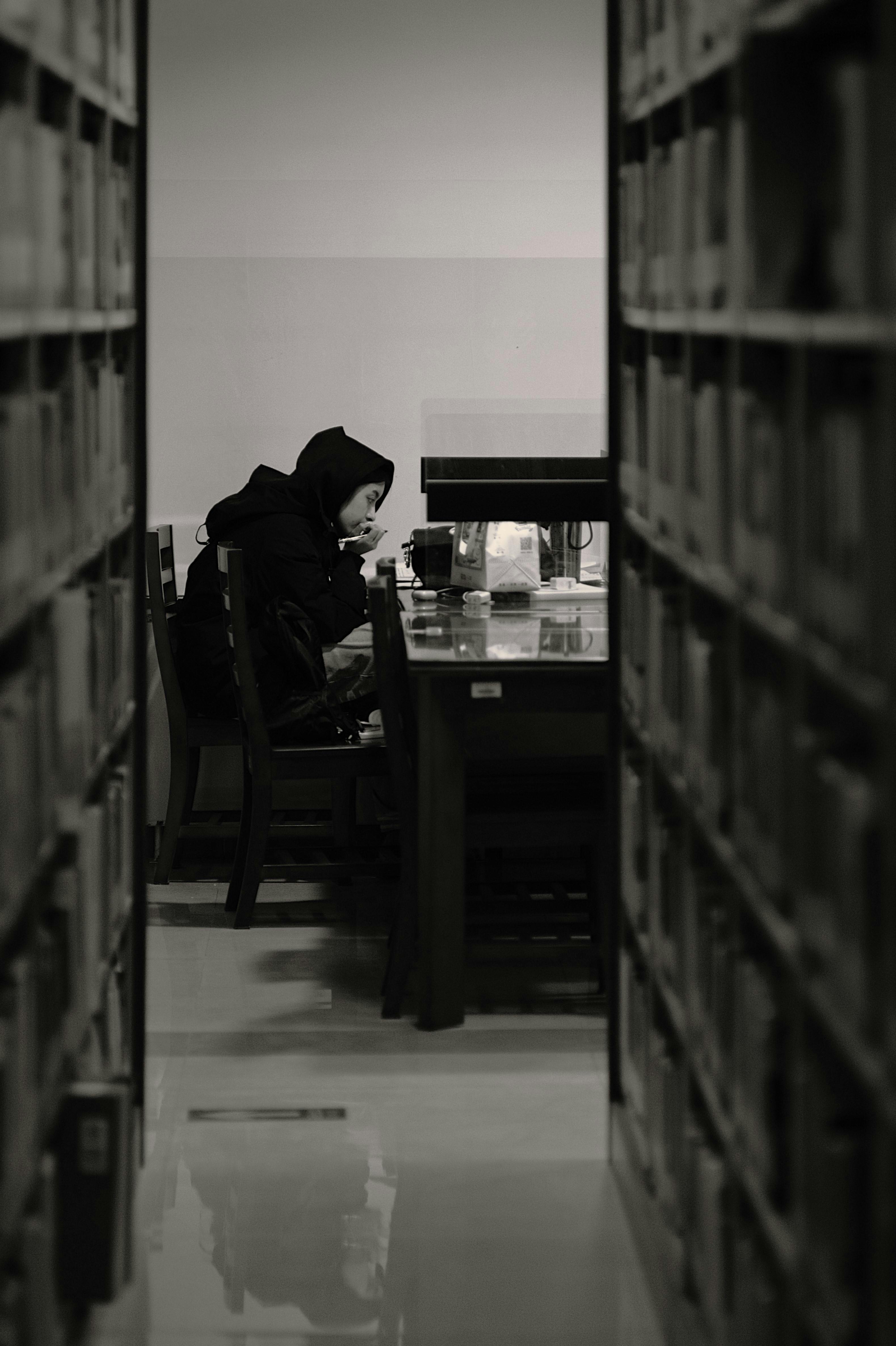 Woman studying in a library, focused and serene environment.