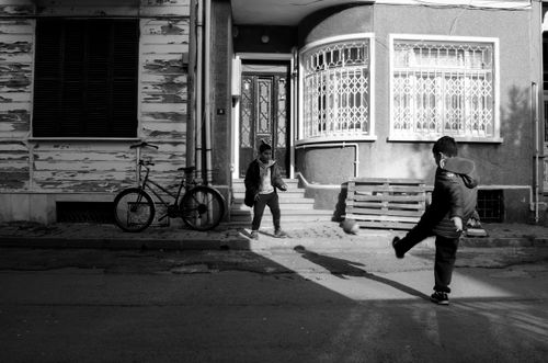Free Two boys play soccer in a black and white urban setting, capturing the essence of childhood joy. Stock Photo