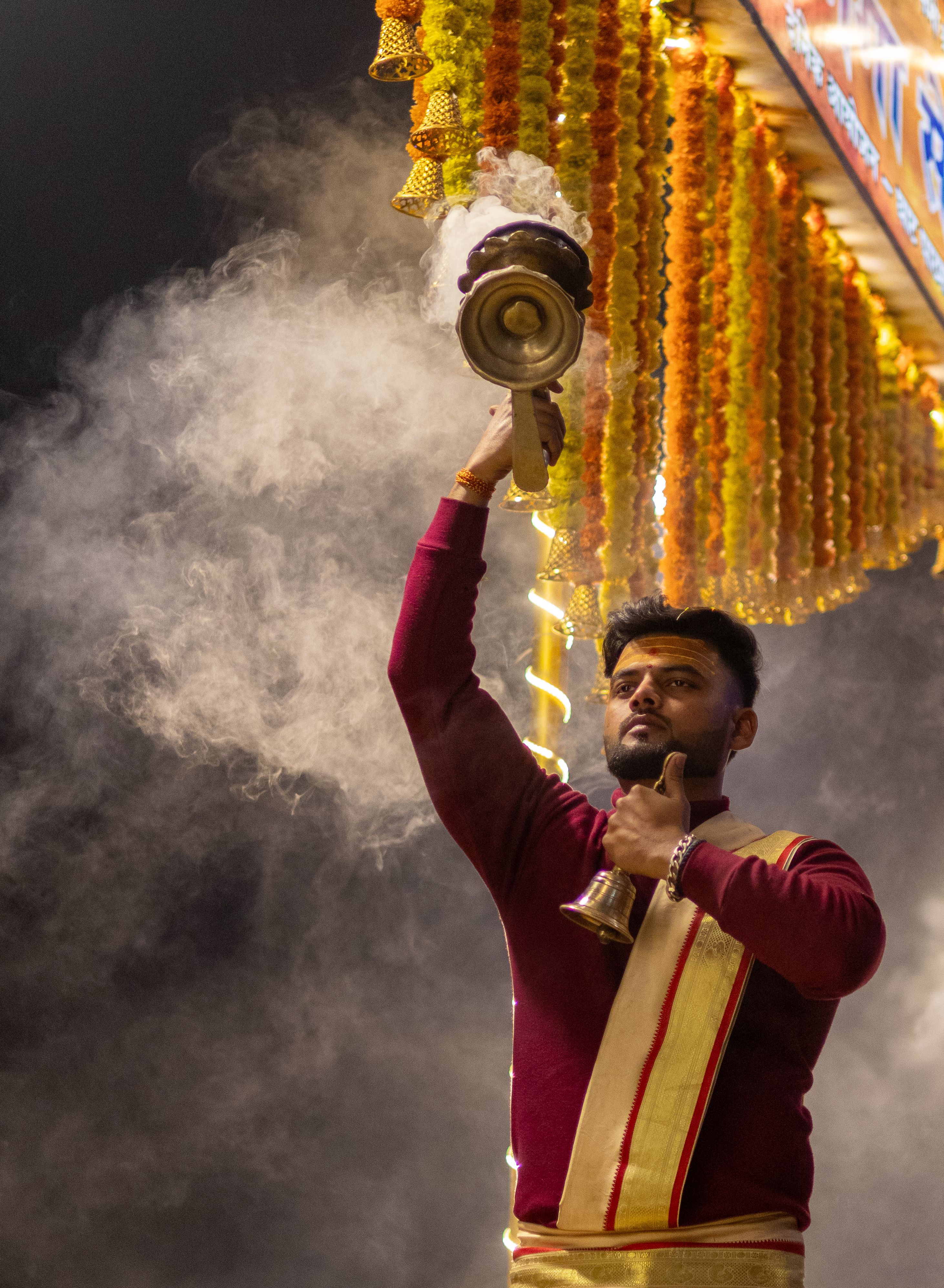 Priest performing traditional Ganga Aarti ceremony on the ghats of Varanasi, Uttar Pradesh, India.