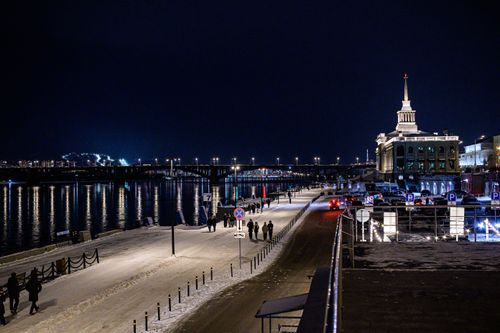 Free Beautiful waterfront scene at night with a historic building and illuminated bridge. Stock Photo