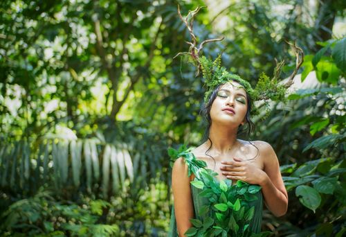 Free A woman in a nature-inspired costume embodies a forest nymph with antler headpiece. Stock Photo
