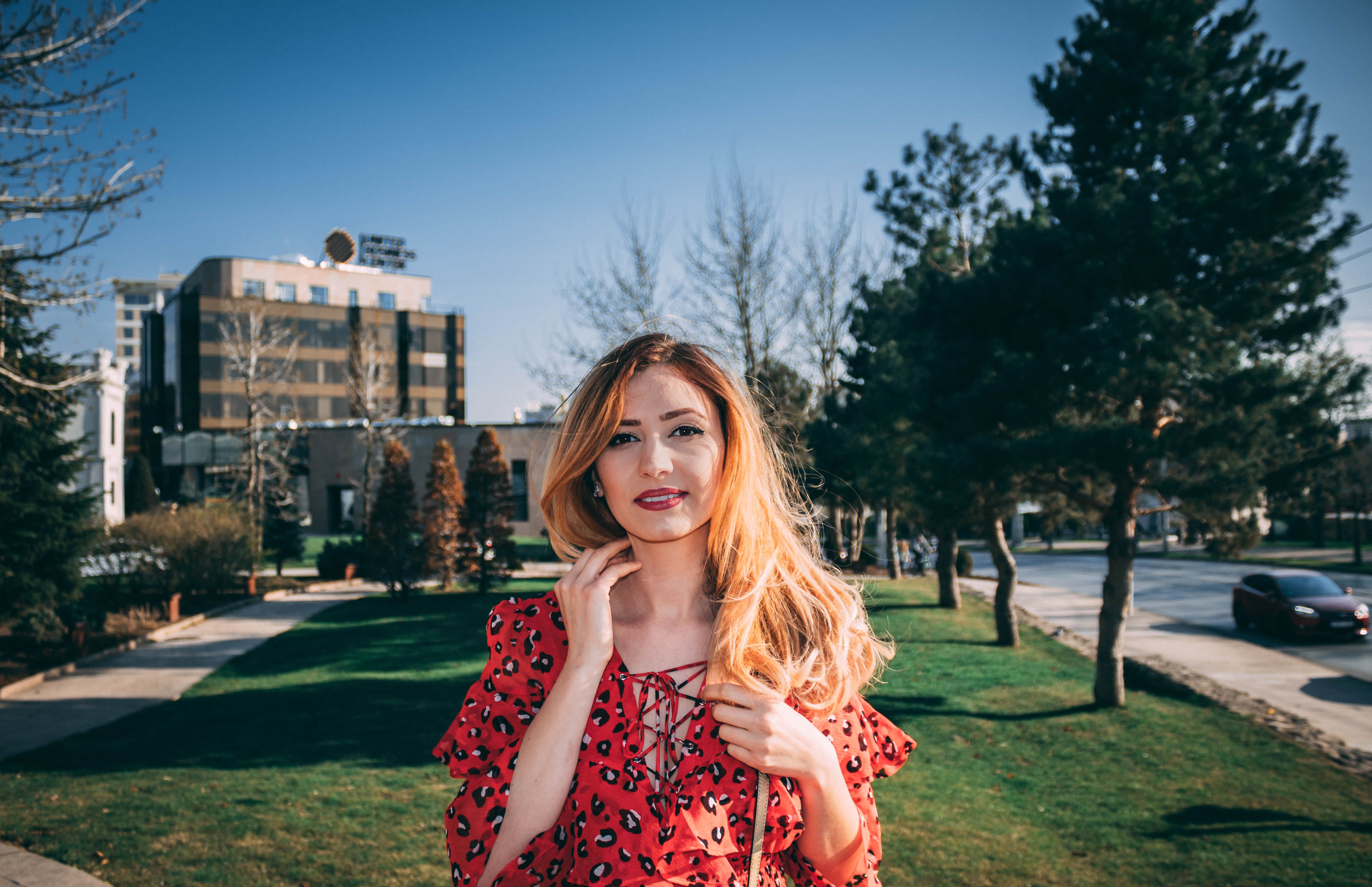 Young Woman in Red Dress Outdoors in City Park · Free Stock Photo