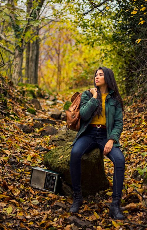 Free A young woman in a forest with colorful autumn leaves, carrying a backpack. Stock Photo