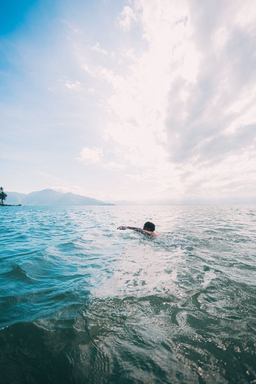 Free A swimmer enjoying the serene waters of Ilhabela, São Paulo, Brazil, under a bright sky. Stock Photo
