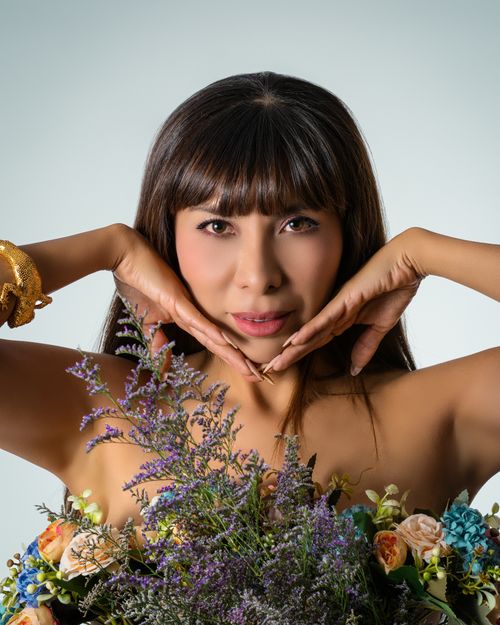 Free Striking portrait of a woman surrounded by vibrant flowers, exuding natural beauty. Stock Photo