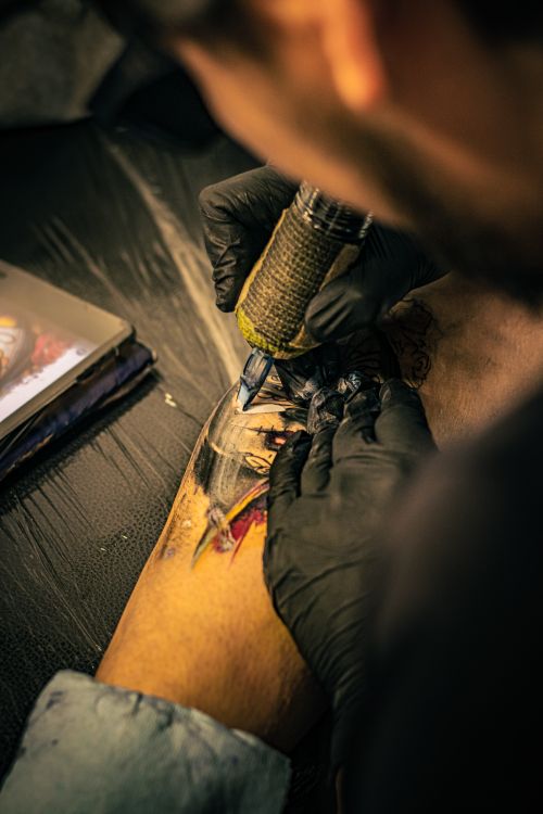 Free Tattoo artist using needle to create intricate tattoo on leg in Mexico City Stock Photo
