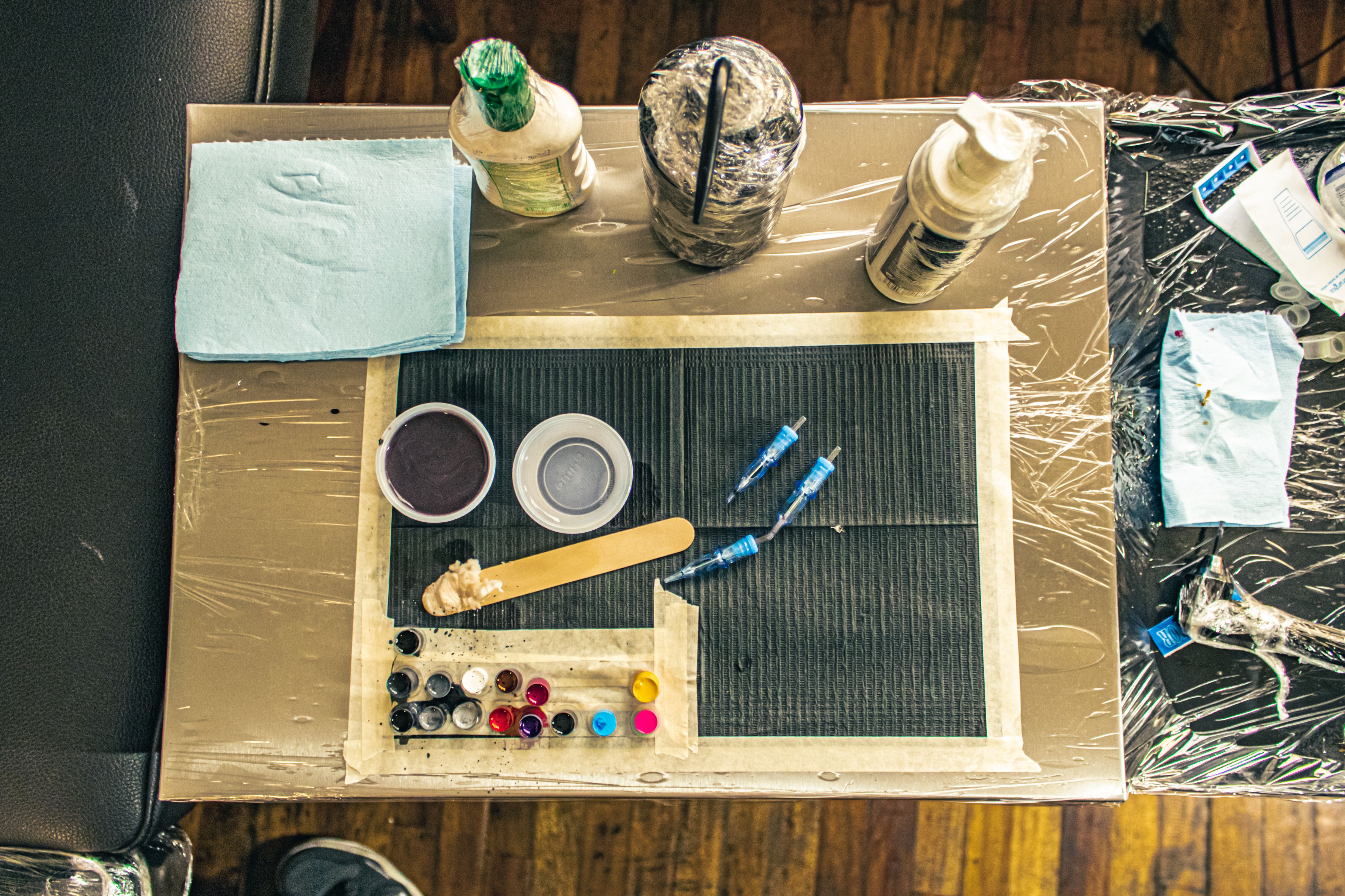 Organized tattoo studio workspace featuring inks, needles, and professional tools on a workbench, capturing the artistic preparation behind every meaningful footballer tattoo