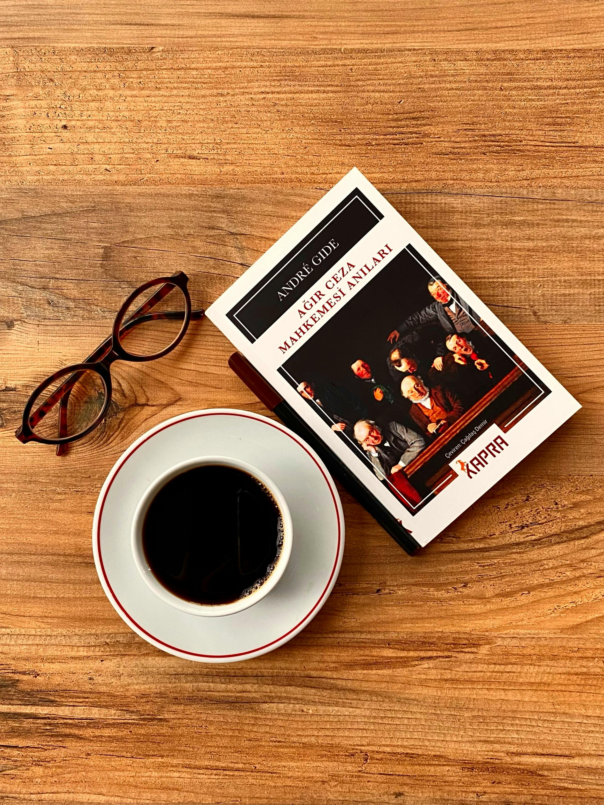 grátis Uma composição aconchegante de um livro, uma xícara de café e óculos sobre uma mesa de madeira, perfeita para os amantes da leitura. Foto profissional