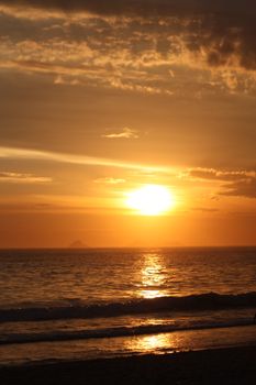 A stunning sunset over the ocean at a Rio de Janeiro beach, capturing the warm summer glow.