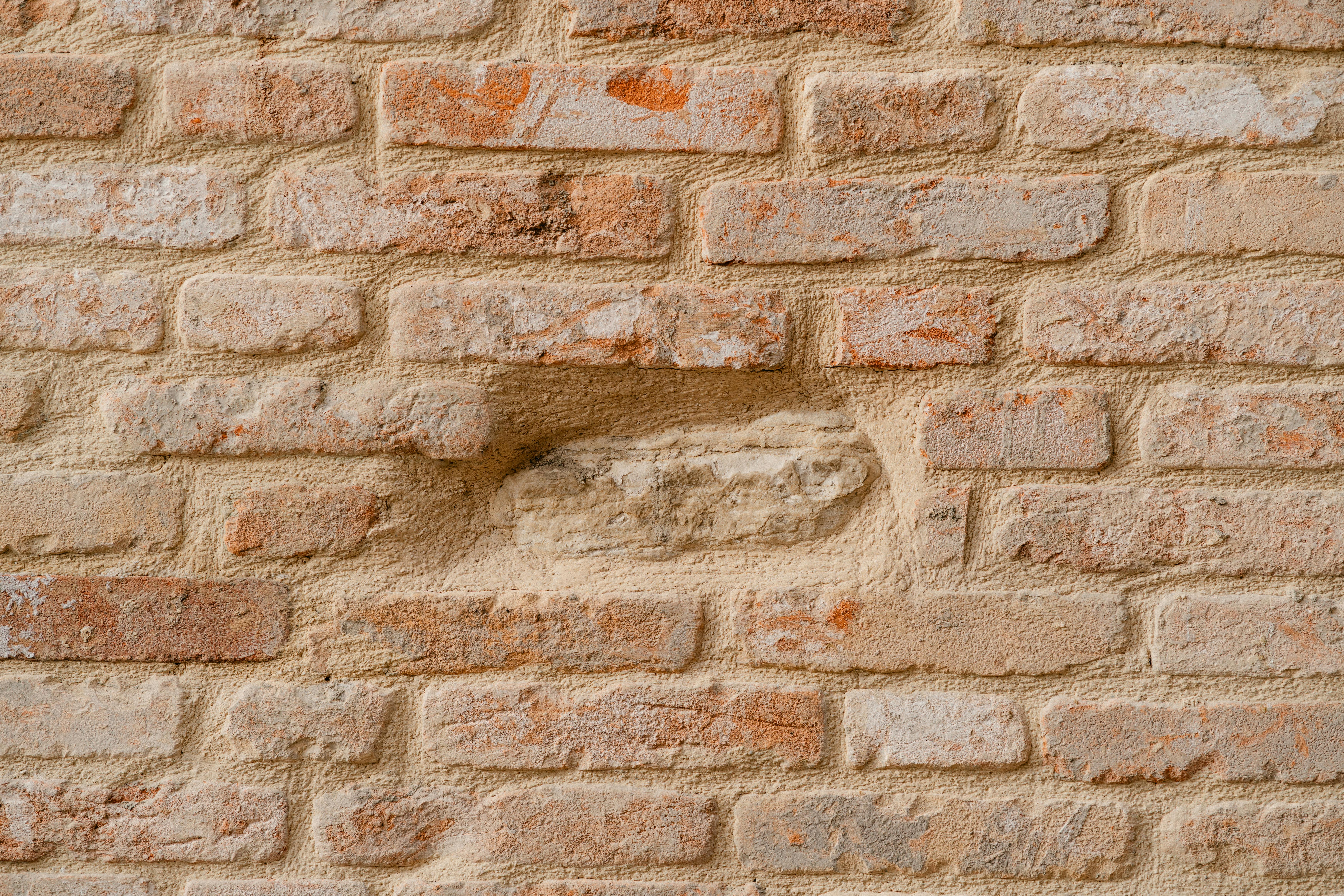Miễn phí Hình ảnh cận cảnh chi tiết của một bức tường gạch cũ kỹ, thể hiện rõ kết cấu phong phú và màu sắc mộc mạc. Ảnh lưu trữ