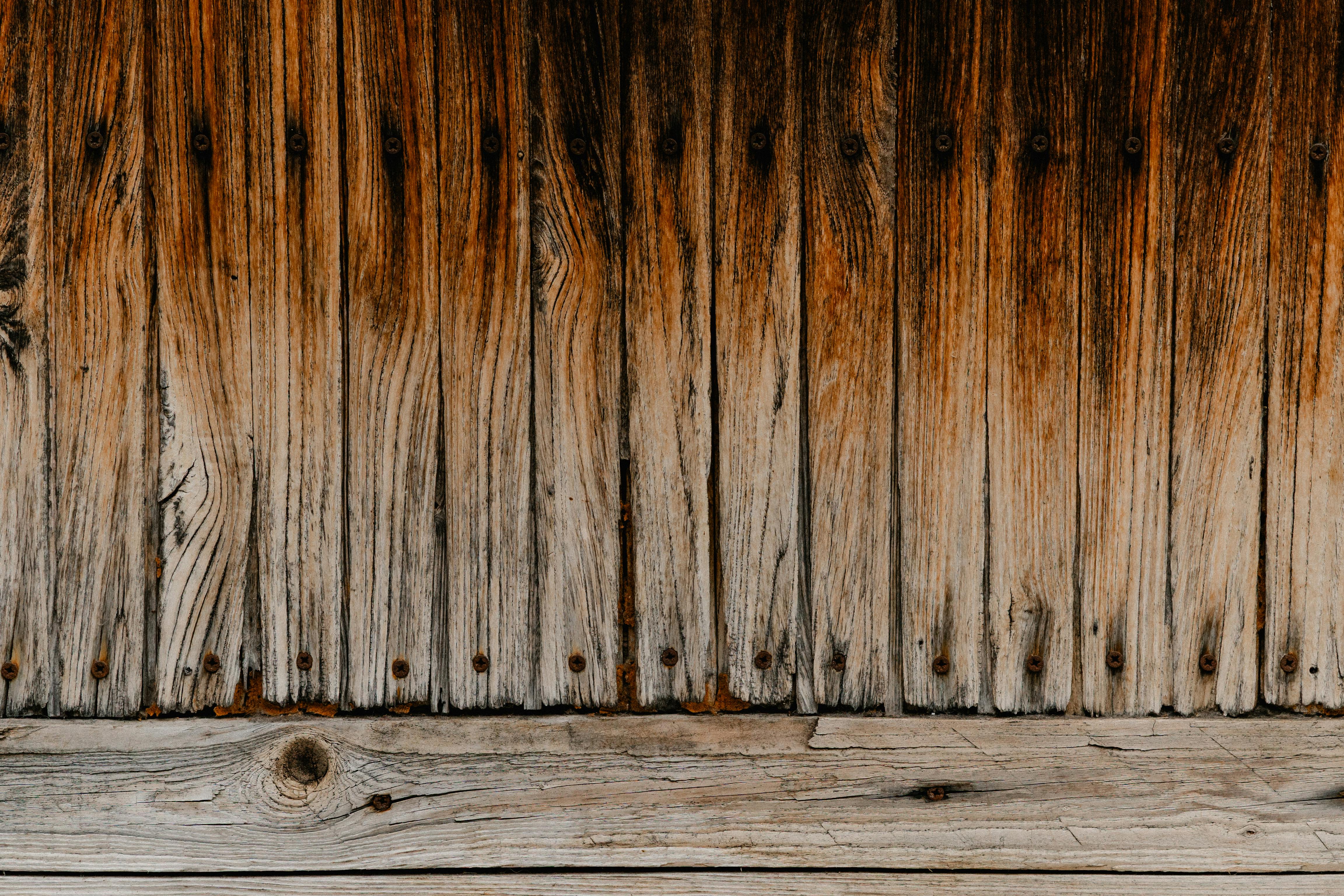 Gratis Primo piano di assi di legno invecchiate con texture ricche e tonalità terrose. Foto a disposizione