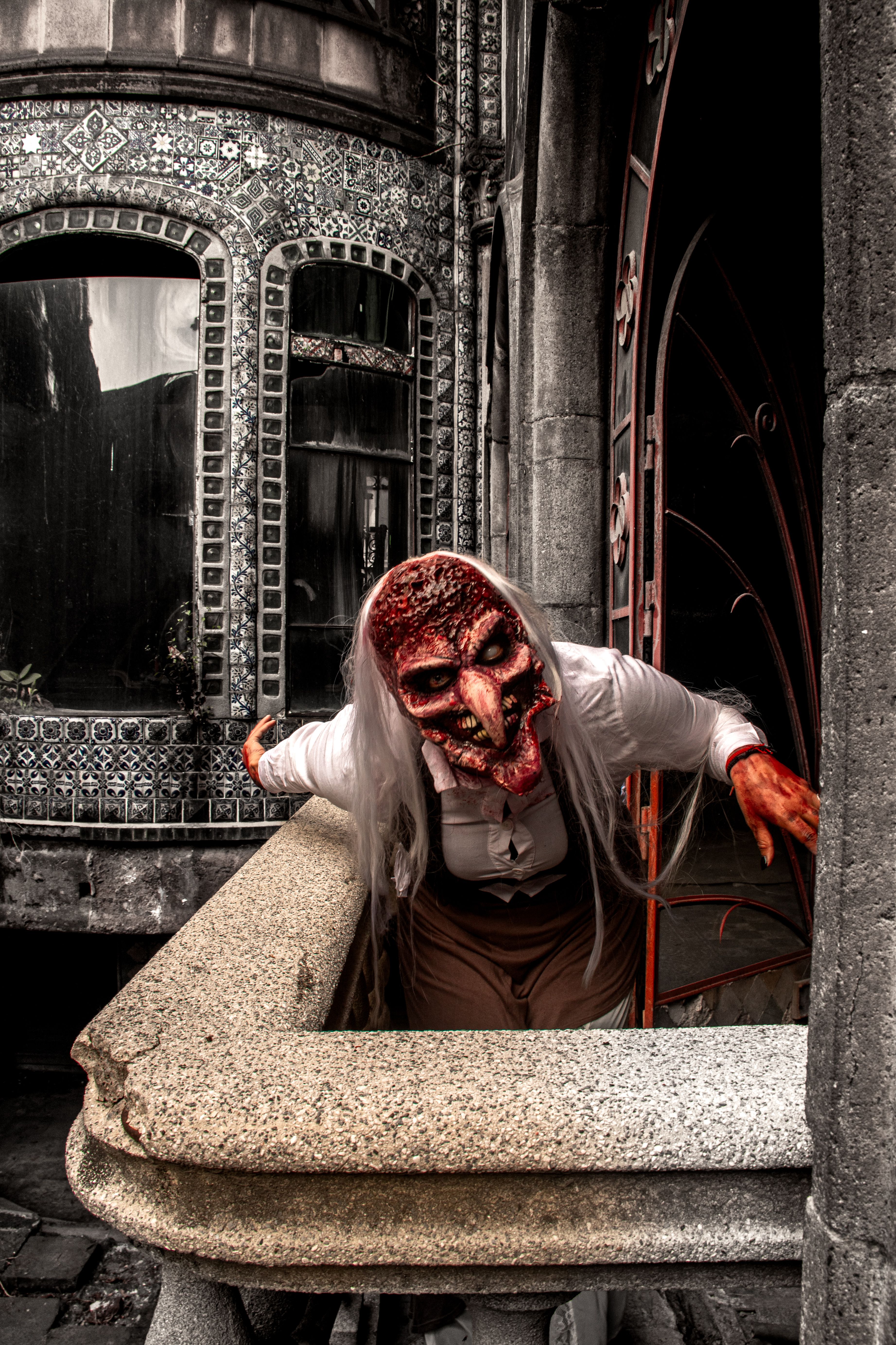 Creepy figure in a witch mask at an old haunted mansion. Perfect for Halloween themes.