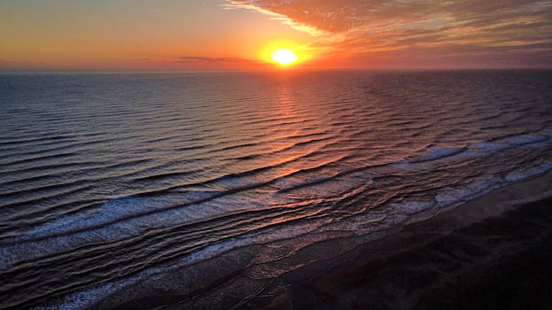 Stunning aerial view of a tranquil ocean sunrise at Costa Azul, Argentina, capturing the serene beauty of the early hours.