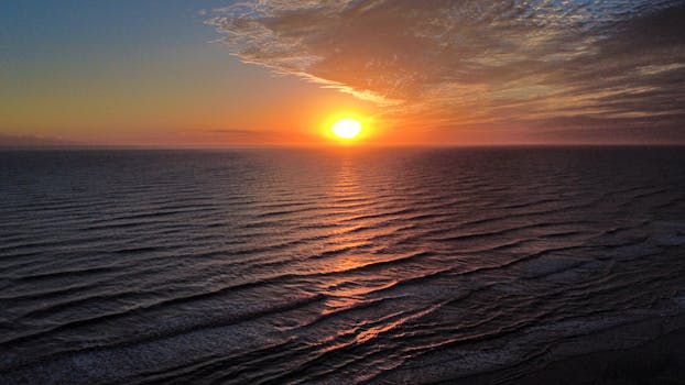 A breathtaking aerial view of the sunrise illuminating the tranquil waters of Costa Azul, Argentina.