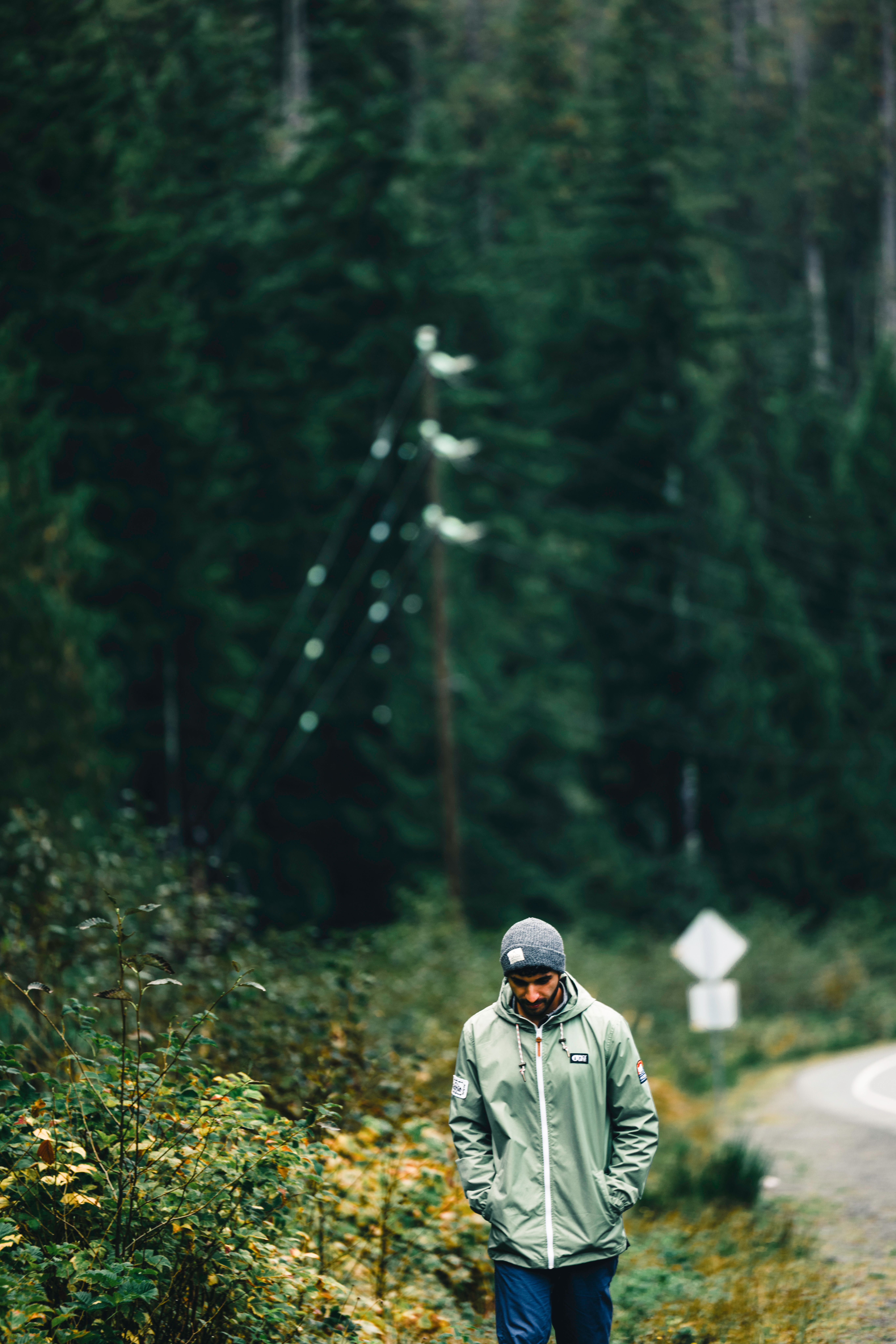 A solitary man walks along a forest path in Tofino, capturing the essence of outdoor adventure.