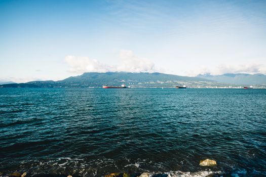 Breathtaking view of Vancouver's coastline with distant mountains under a clear blue sky.